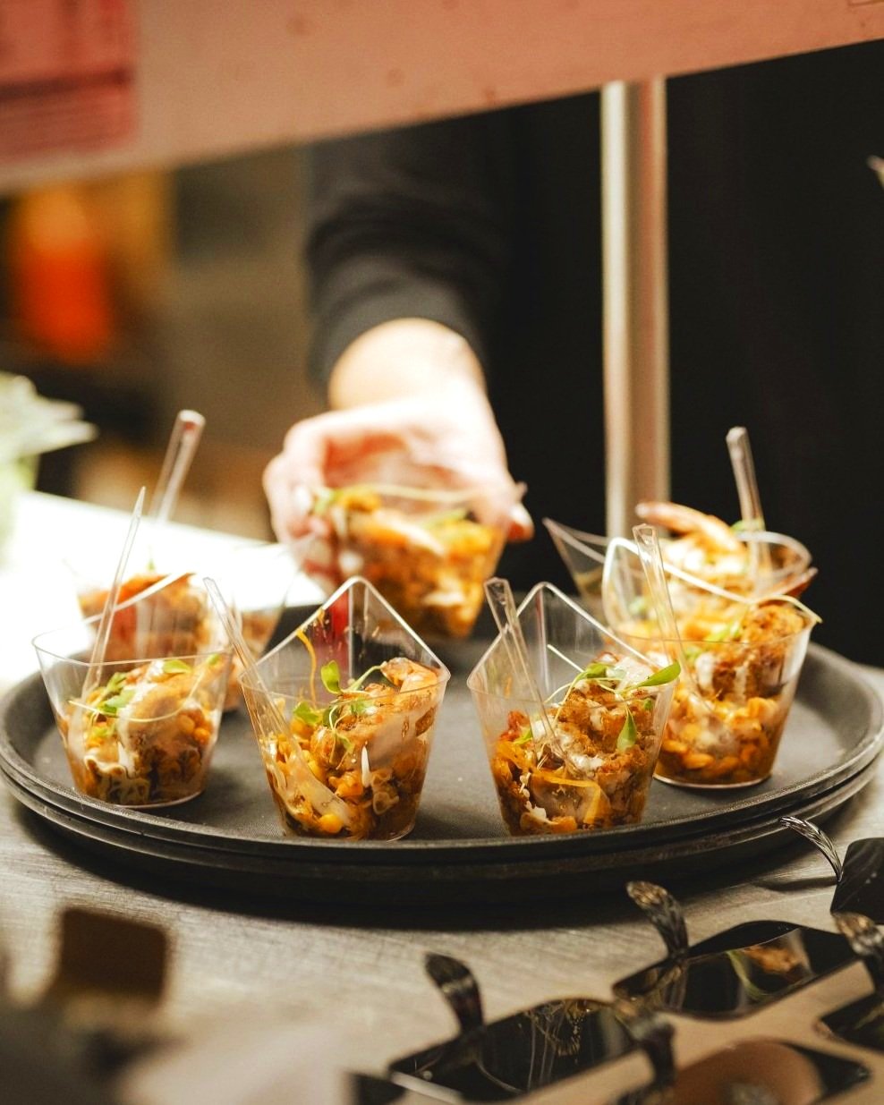 Hostess placing a Le Rouge Cuisine appetizer on a tray.